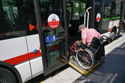 Photo d'une personne en fauteuil roulant montant dans un bus TCL au moyen de la rampe déployable dédiée.