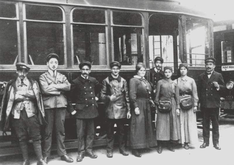 Photographie noir et blanc d'un groupe de personnel des tramways (contrôleurs, receveuses, traminots) en 1914. Photographe anonyme